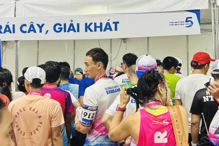 Runner xếp hàng dài nhận nước đồ ăn tại giải HCMC Night Run Eximbank