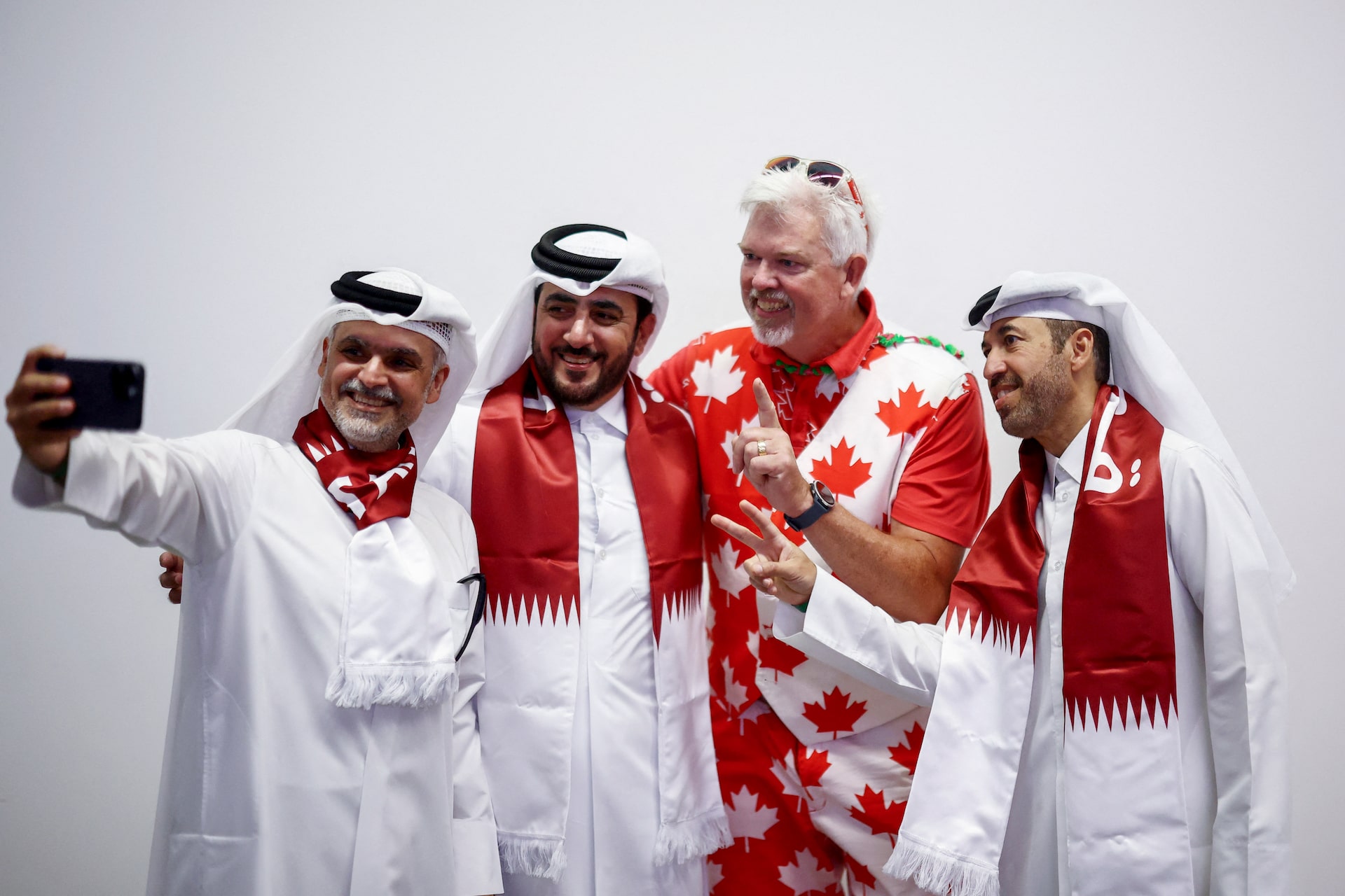 Người hâm mộ Canada và Qatar vui vẻ chụp ảnh kỷ niệm cùng nhau trên khán đài sân vận động